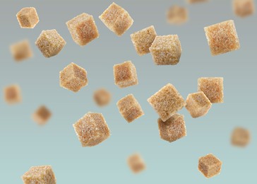 Image of Brown cane sugar cubes falling on color gradient background