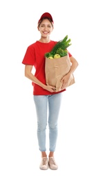 Delivery woman with bag of fresh vegetables on white background