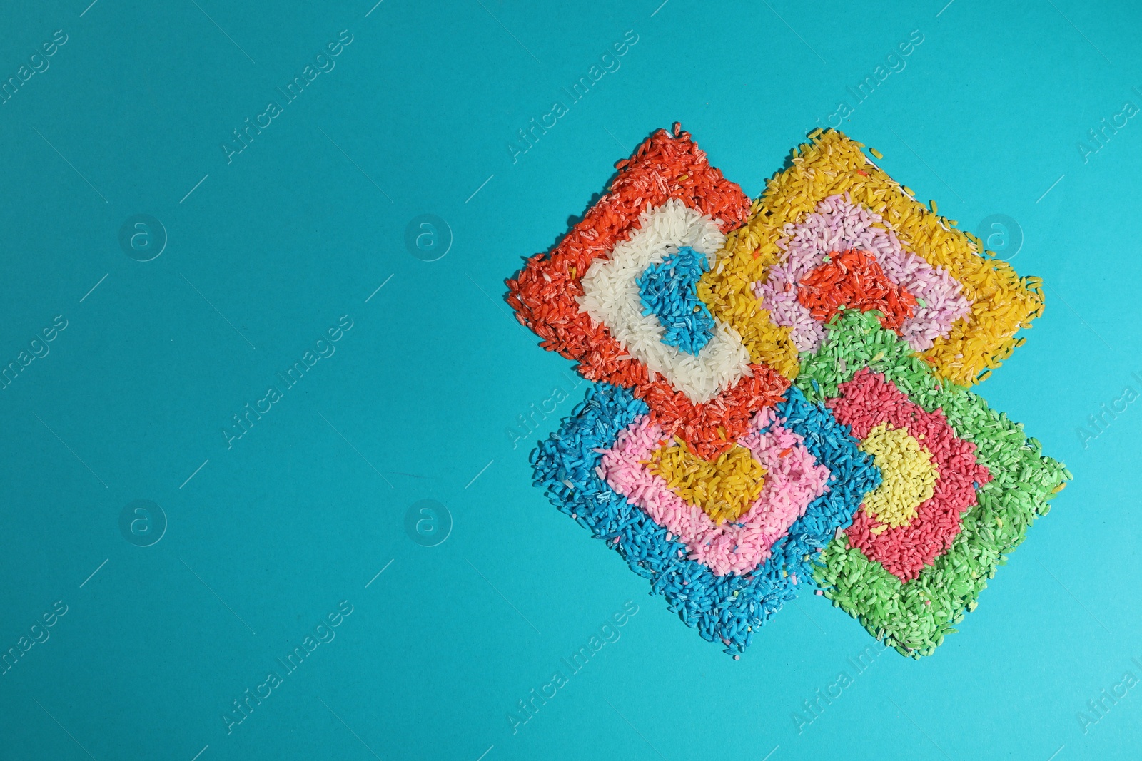 Photo of Diwali celebration. Colorful rangoli on light blue background, top view. Space for text