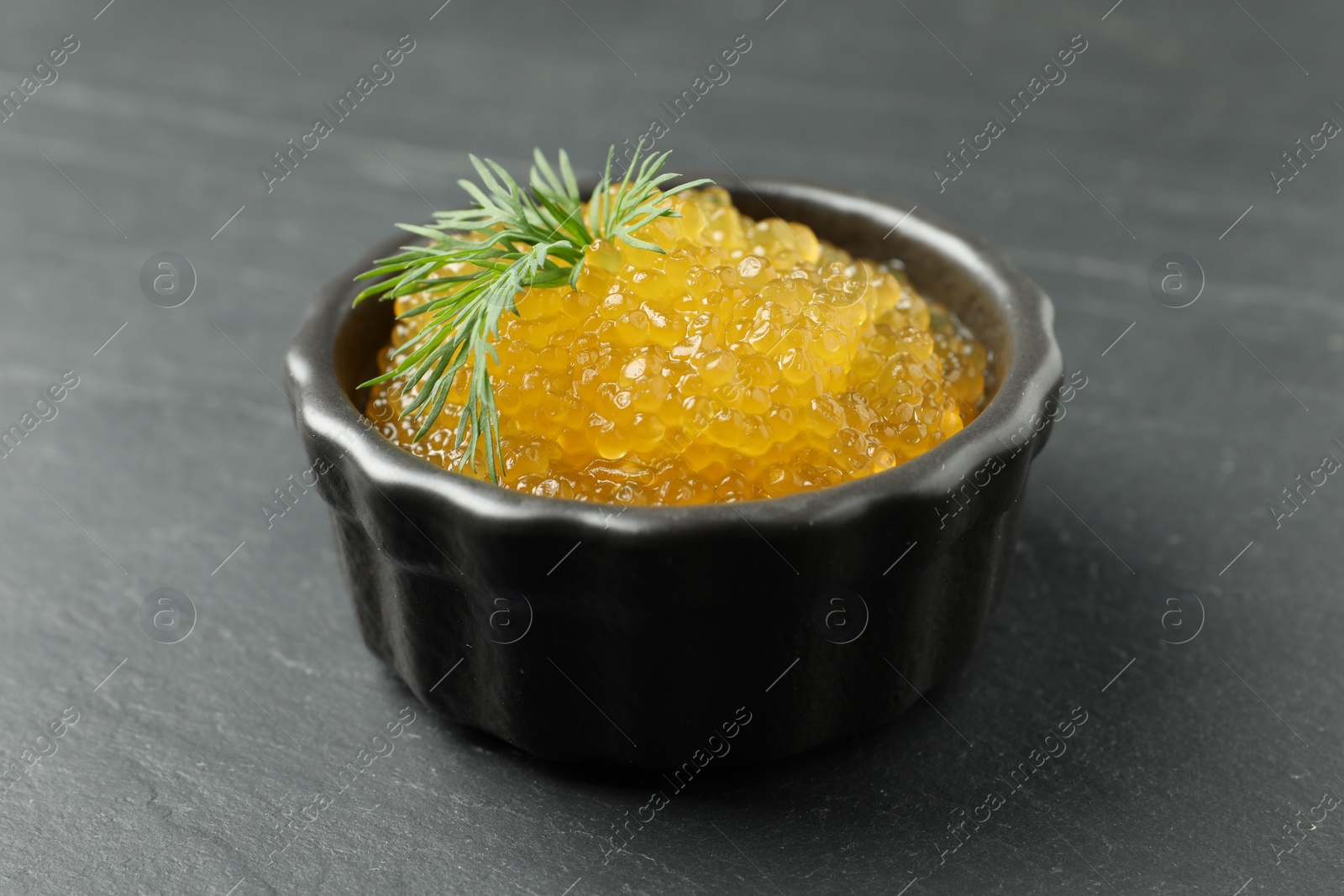 Photo of Fresh pike caviar in bowl on black table