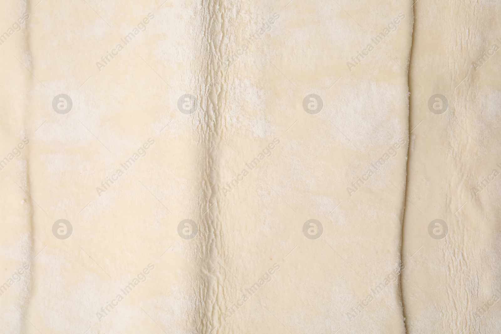 Photo of Raw puff pastry dough as background, top view