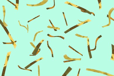 Image of Shiny golden confetti falling on turquoise background
