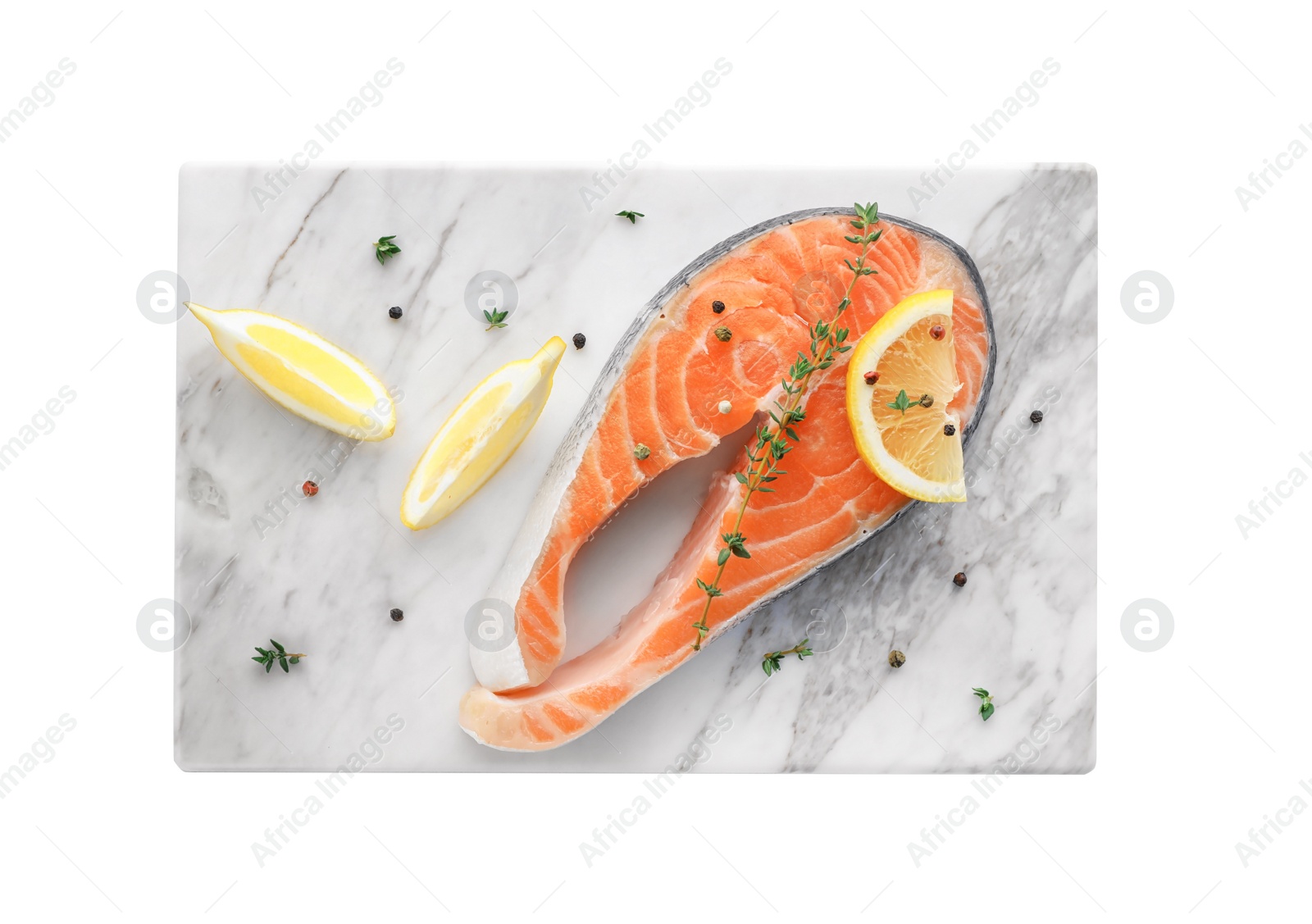 Photo of Marble board with fresh salmon steak and lemon on white background, top view