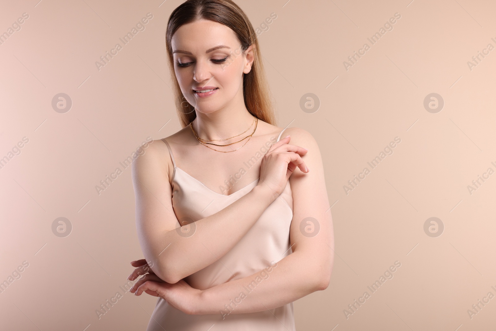 Photo of Beautiful woman with elegant necklace on beige background
