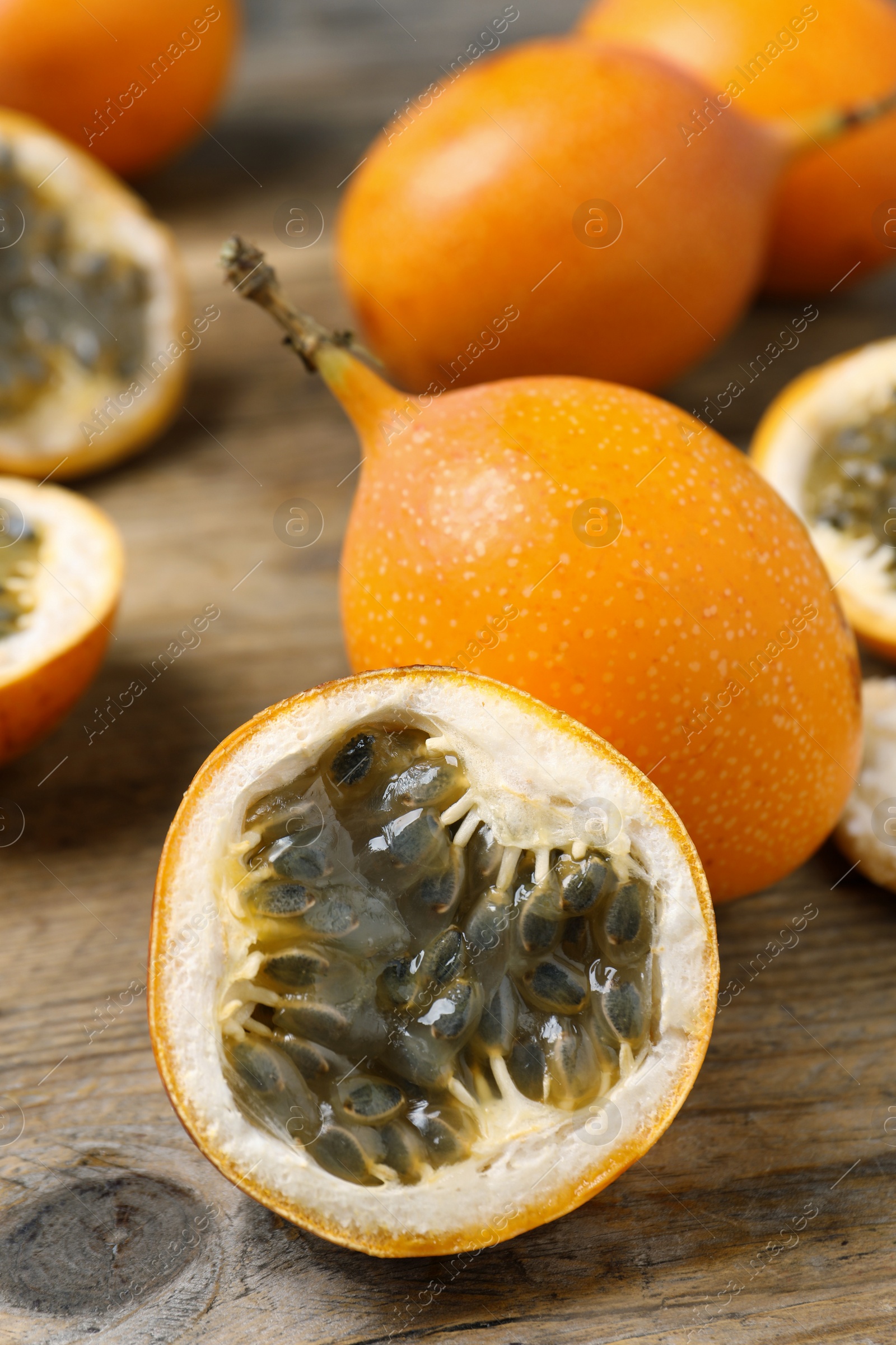 Photo of Delicious ripe granadillas on wooden table, closeup