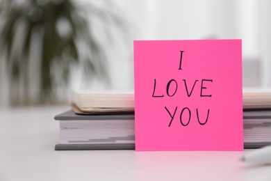 Photo of Memory sticker with phrase I Love You at table, space for text. Valentine's Day celebration