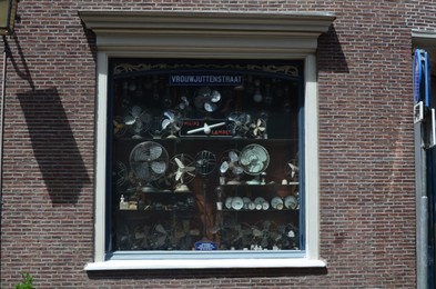Photo of UTRECHT, NETHERLANDS - JULY 09, 2022: Showcase of store with vintage fans and clocks outdoors
