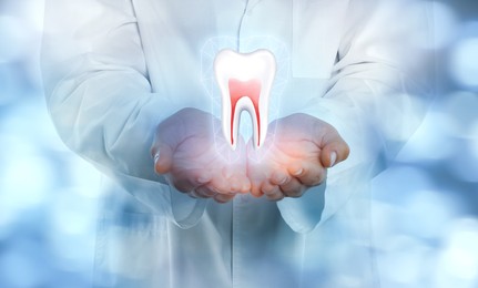 Dentist showing virtual model of tooth on blurred background, closeup