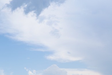 Beautiful fluffy clouds on light blue sky as background