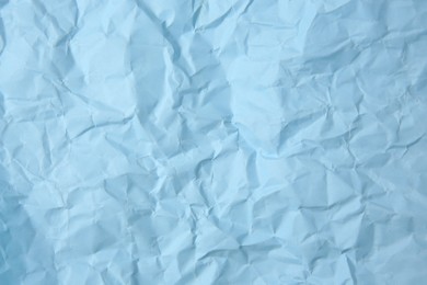 Photo of Sheet of crumpled light blue paper as background, top view