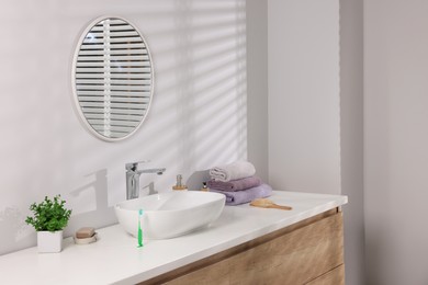 Photo of Stylish bathroom interior with vessel sink and round mirror