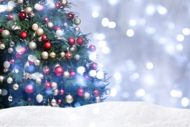 Image of Beautifully decorated Christmas tree and snow on light background, space for text. Bokeh effect