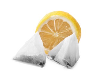 Tea bags and half of lemon on white background