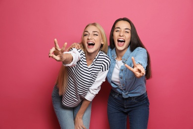 Photo of Young women laughing together against color background