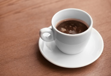 Photo of Cup of aromatic coffee on wooden table