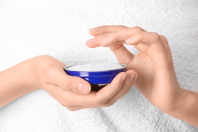 Photo of Young woman with jar of hand cream, closeup
