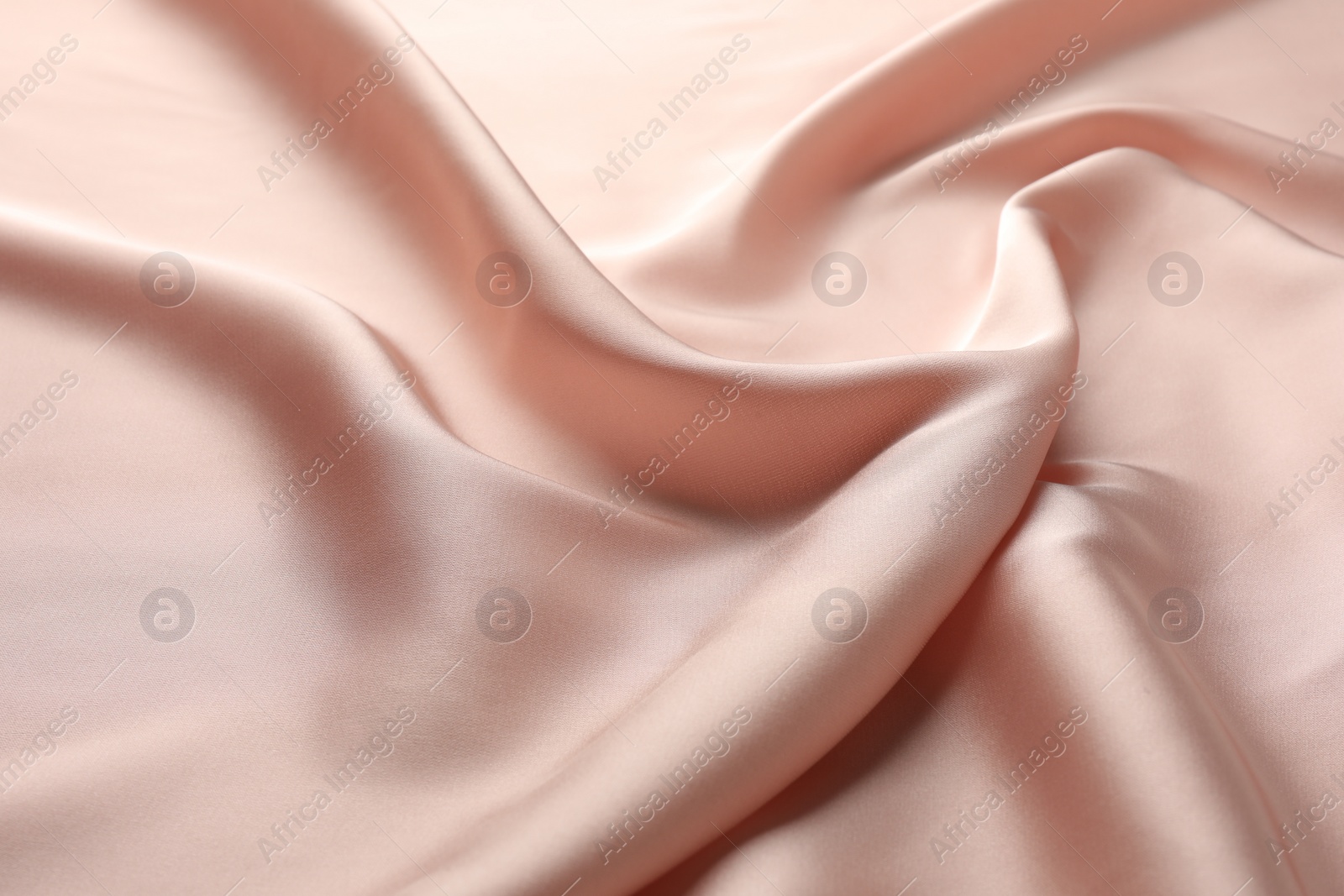 Photo of Crumpled pink silk fabric as background, closeup