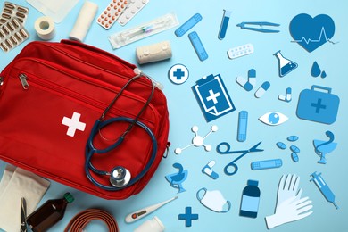 First aid kit and different images on light blue background, flat lay