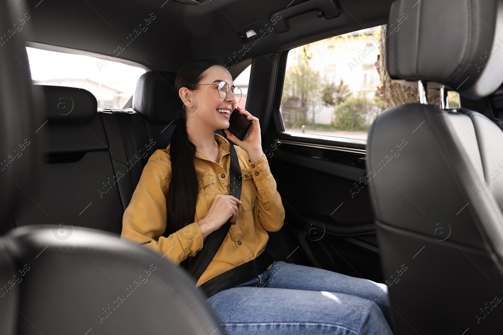 Photo of Woman with seatbelt talking on phone inside car