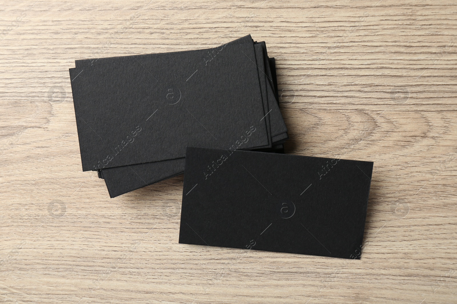 Photo of Blank black business cards on wooden table, top view. Mockup for design