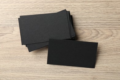 Blank black business cards on wooden table, top view. Mockup for design