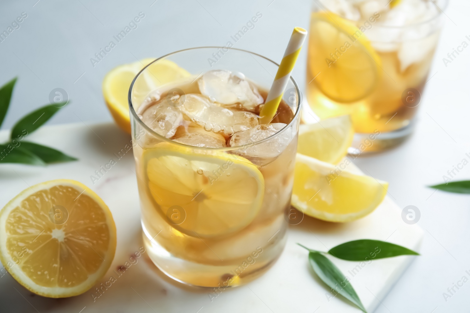 Photo of Glass of lemonade with ice cubes and fruit on table