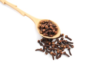 Pile of aromatic dry cloves and wooden spoon on white background, above view