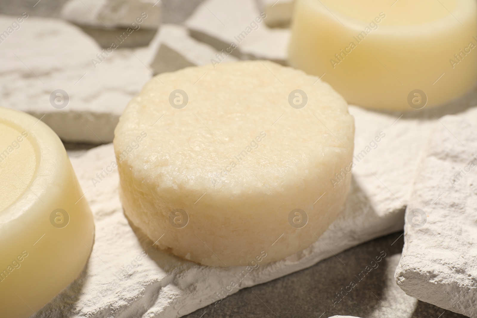 Photo of Solid shampoo bars on light grey table, closeup