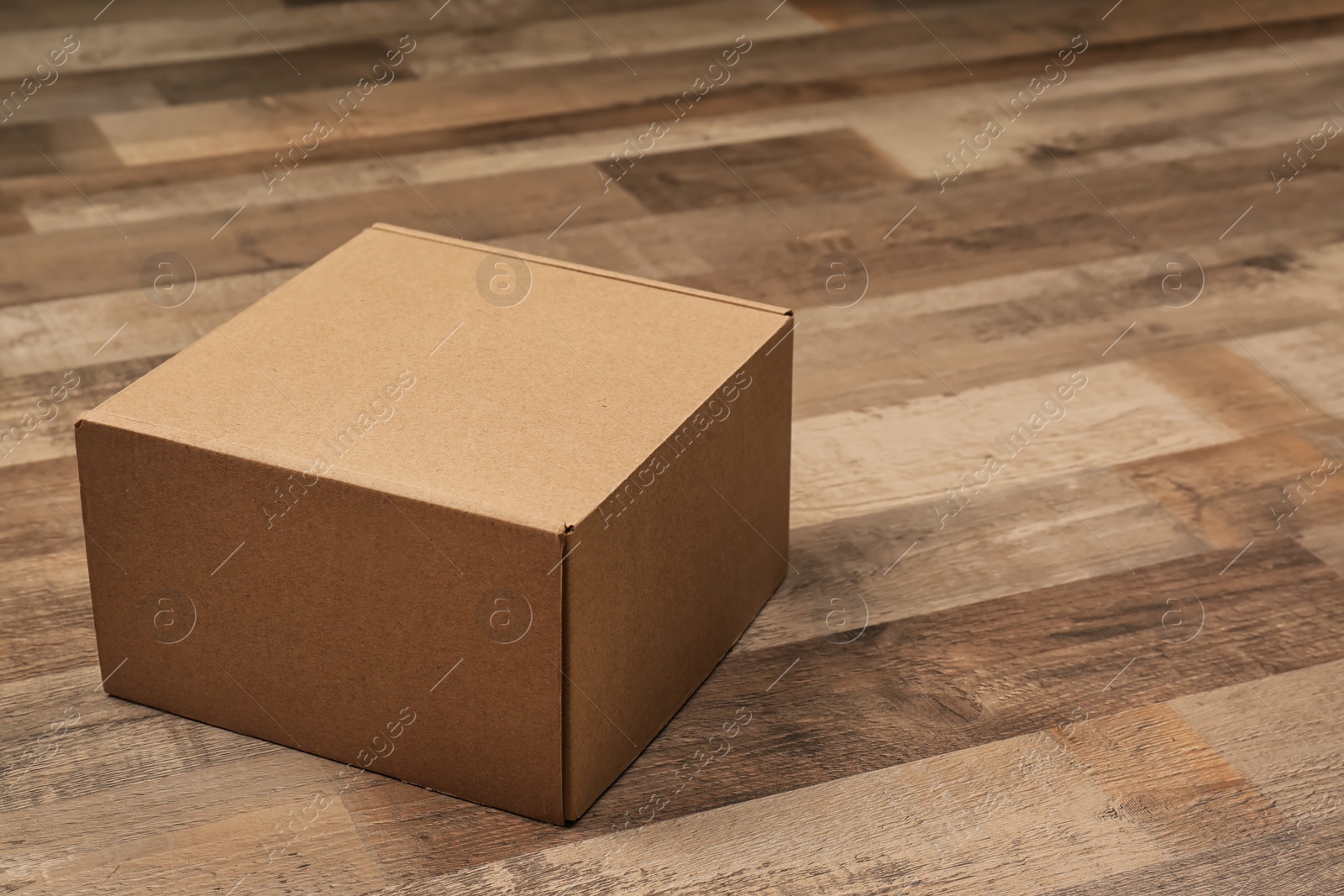 Photo of Cardboard box on wooden floor