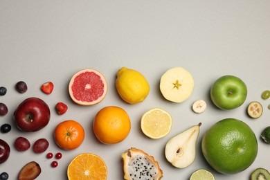 Photo of Different ripe fruits and berries on light gray background, flat lay. Space for text