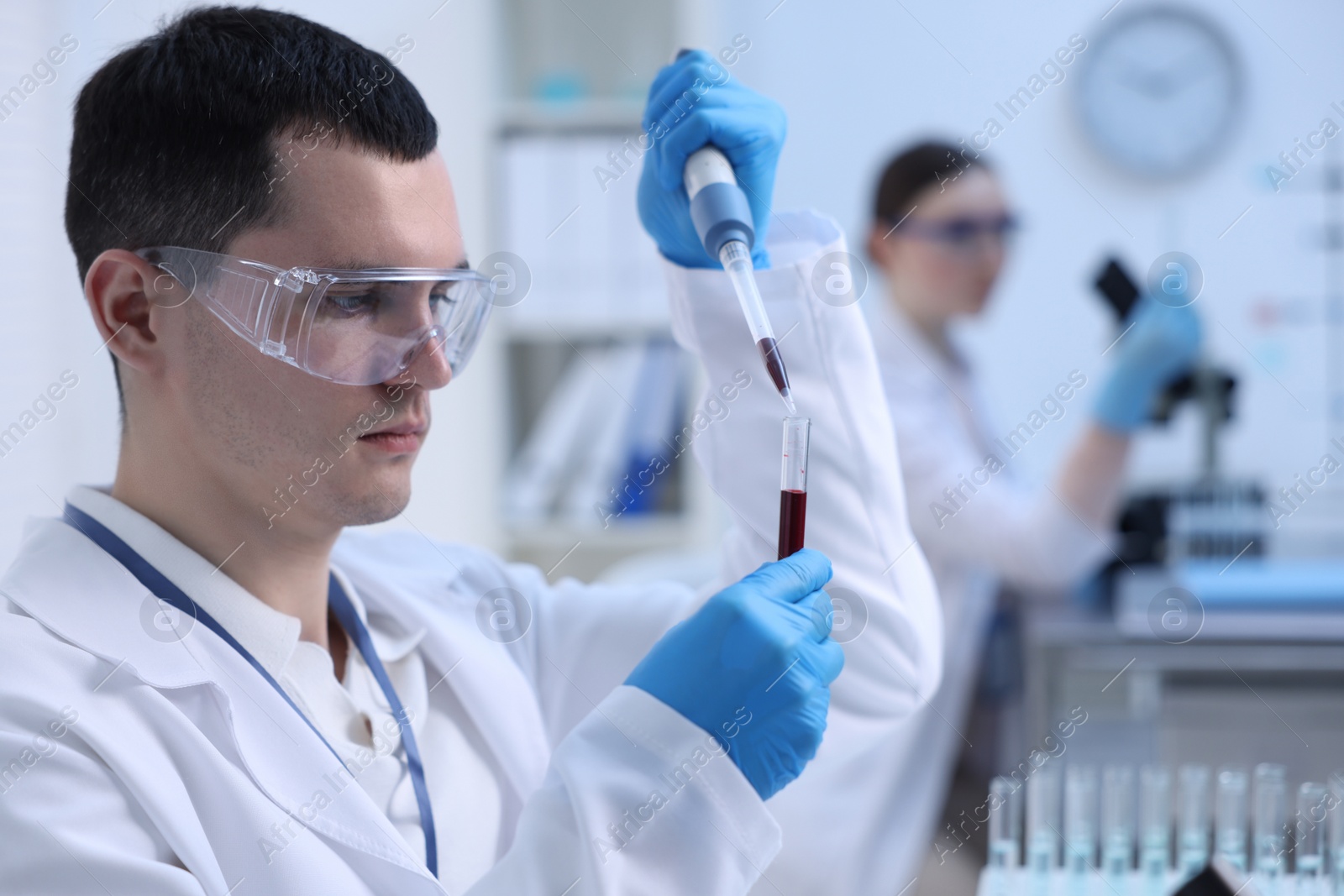 Photo of Scientist dripping sample into test tube in laboratory