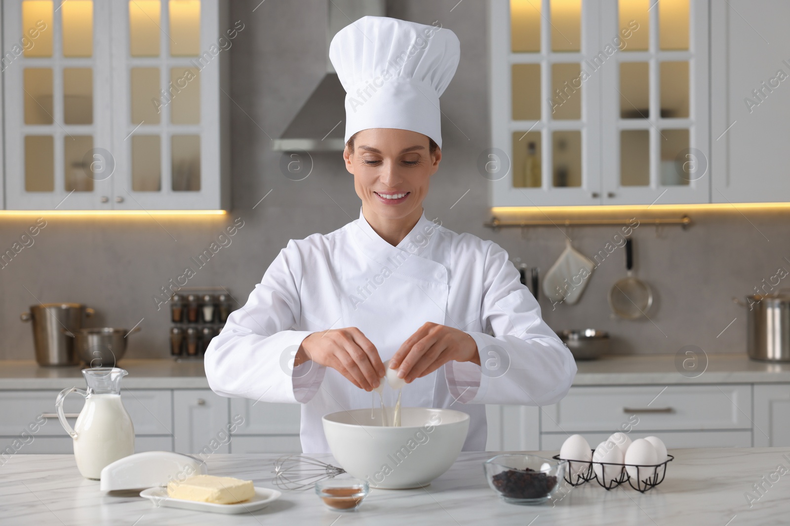 Photo of Professional chef making dough at white marble table in kitchen