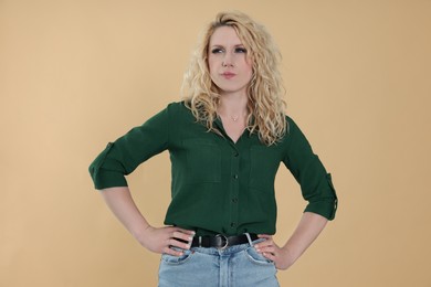 Portrait of thoughtful young woman on beige background