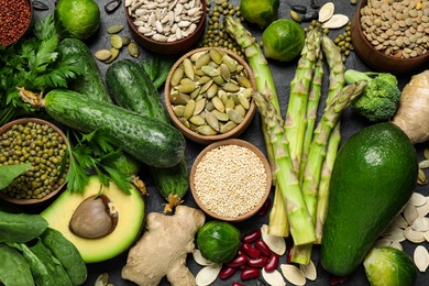 Different vegetables, seeds and fruits on black table, flat lay. Healthy diet