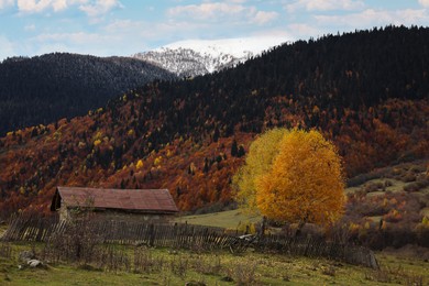 Picturesque view of house in mountains with forest on autumn day