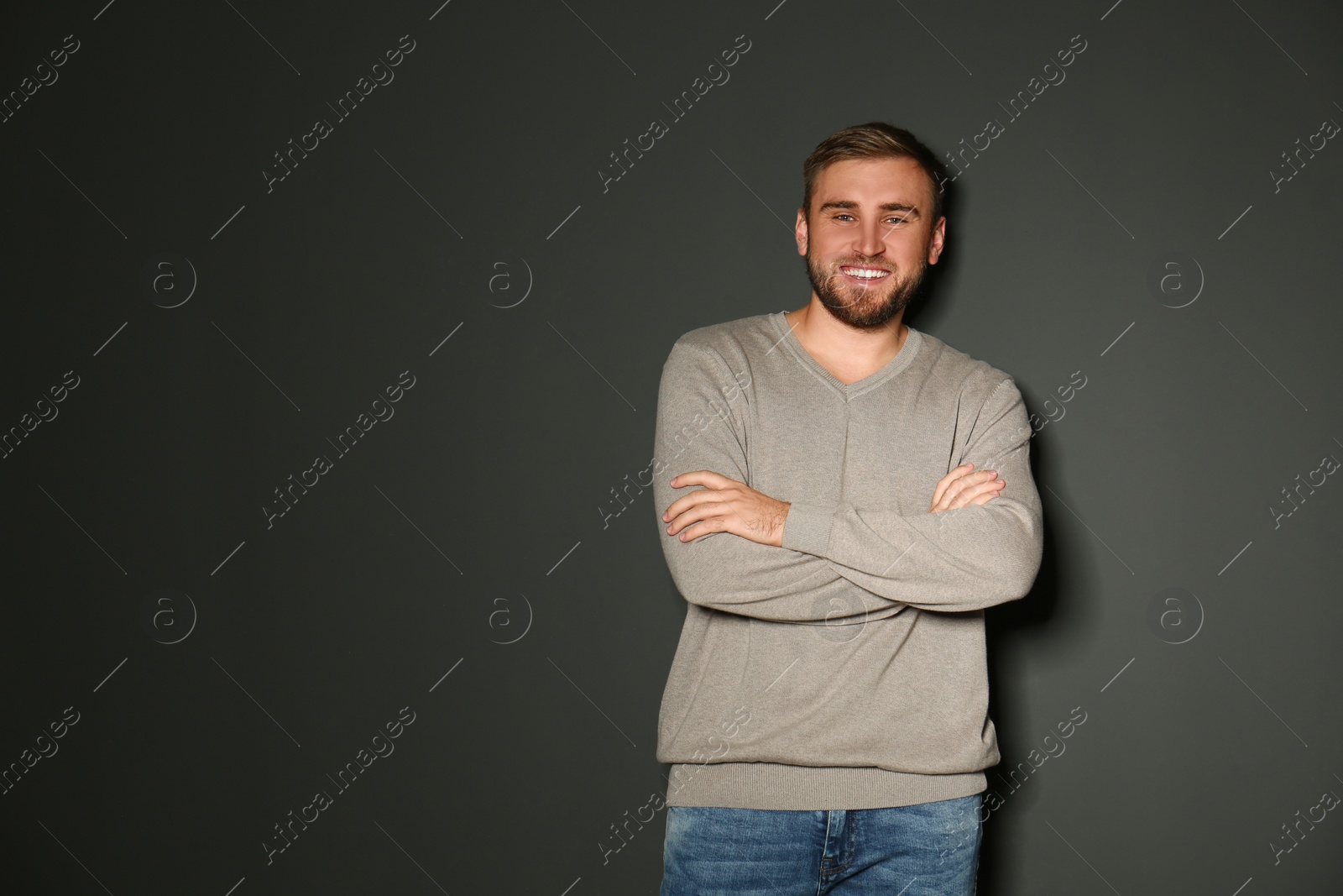 Image of Handsome man wearing warm sweater on dark background. Space for text