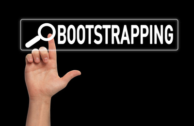 Image of Man touching virtual screen with word BOOTSTRAPPING in search bar on black background, closeup