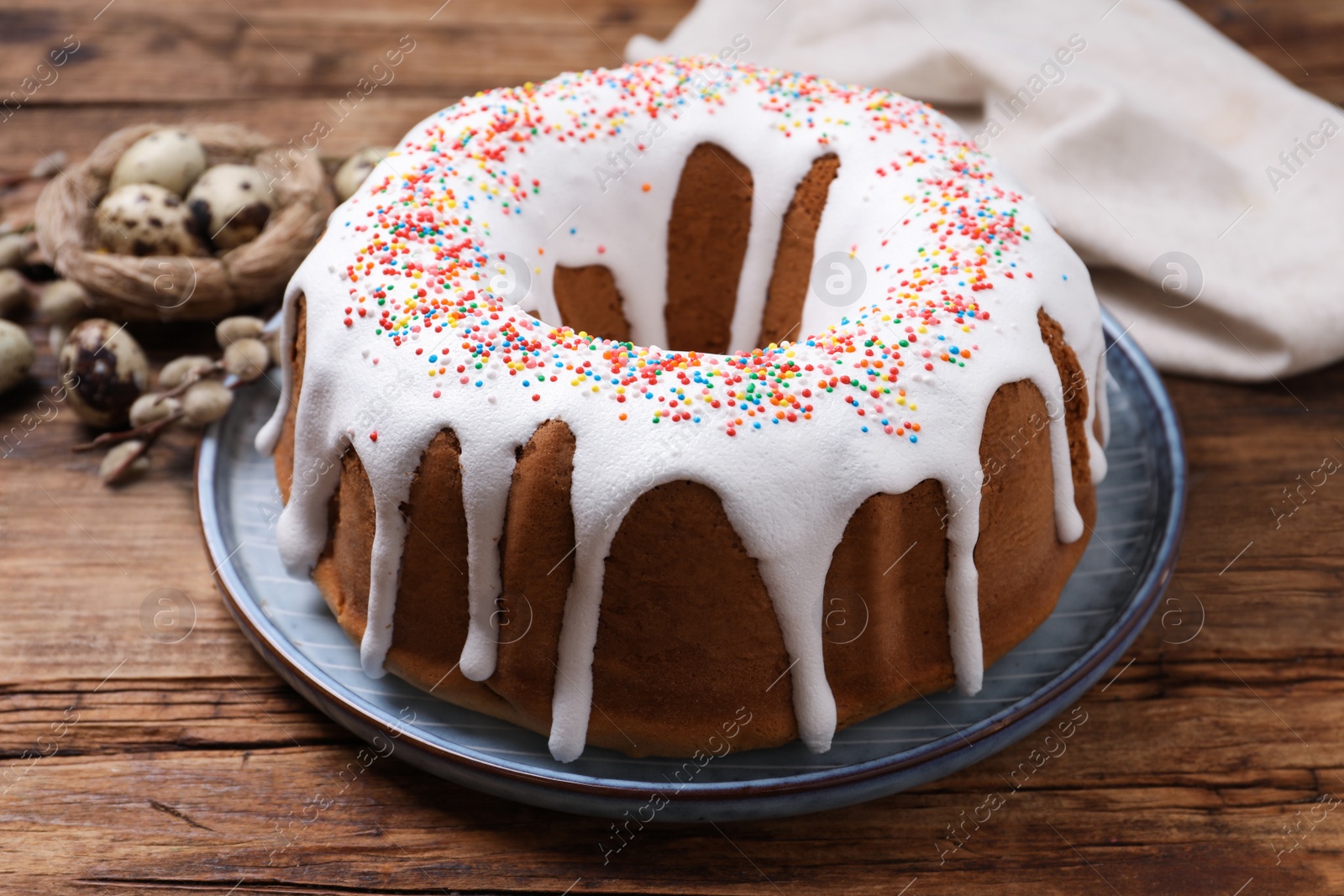 Photo of Glazed Easter cake with sprinkles on wooden table