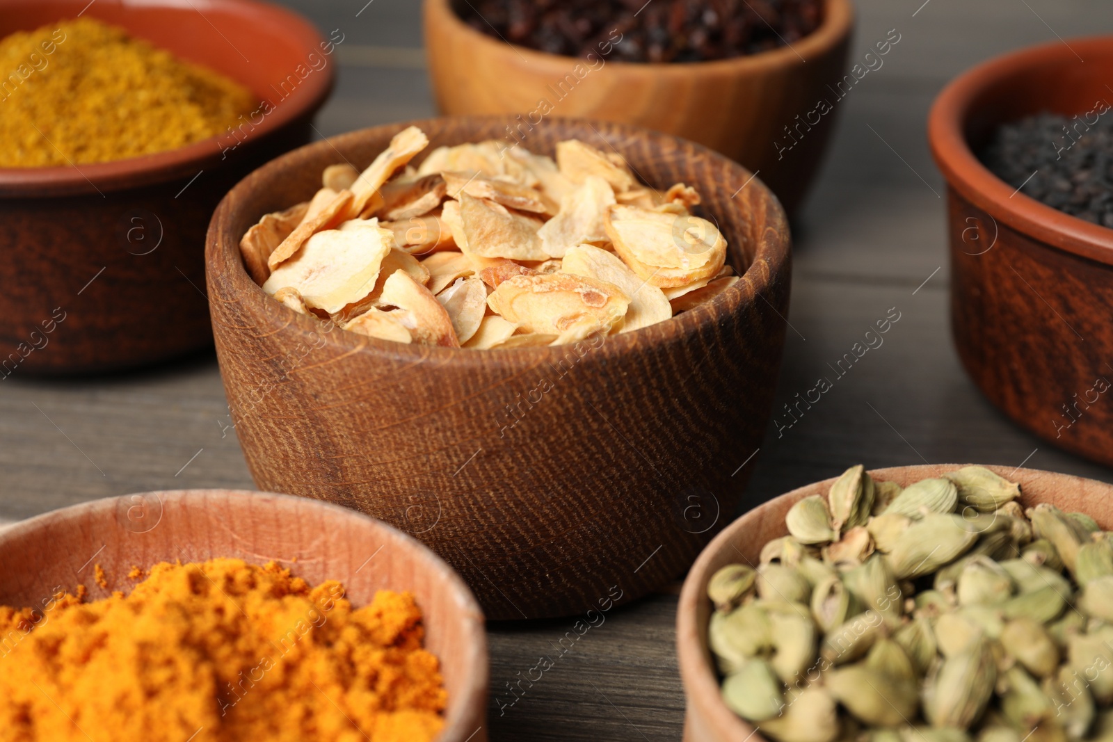Photo of Many different spices on grey wooden table, closeup