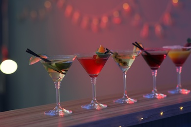 Photo of Different martini cocktails on table in bar