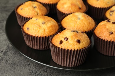 Photo of Delicious freshly baked muffins with chocolate chips on table, closeup