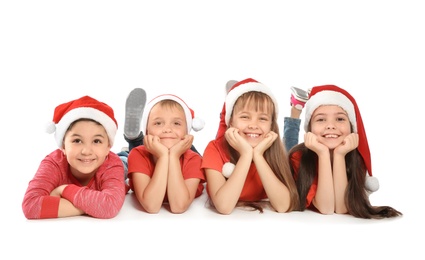 Photo of Cute little children in Santa hats on white background. Christmas celebration