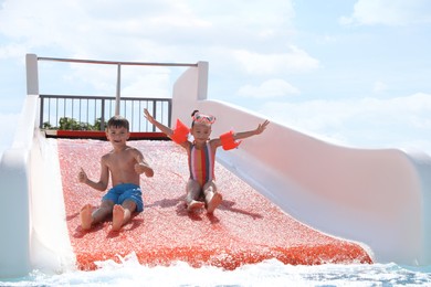 Photo of Cute little children on slide in water park