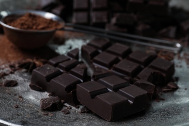 Photo of Delicious dark chocolate on metal plate, closeup