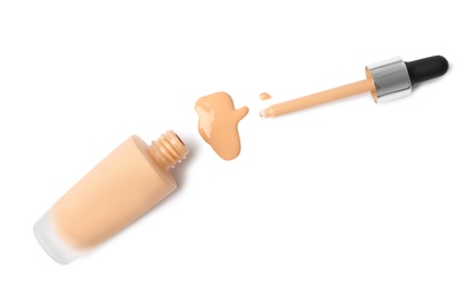 Bottle of liquid foundation and dropper on white background, top view