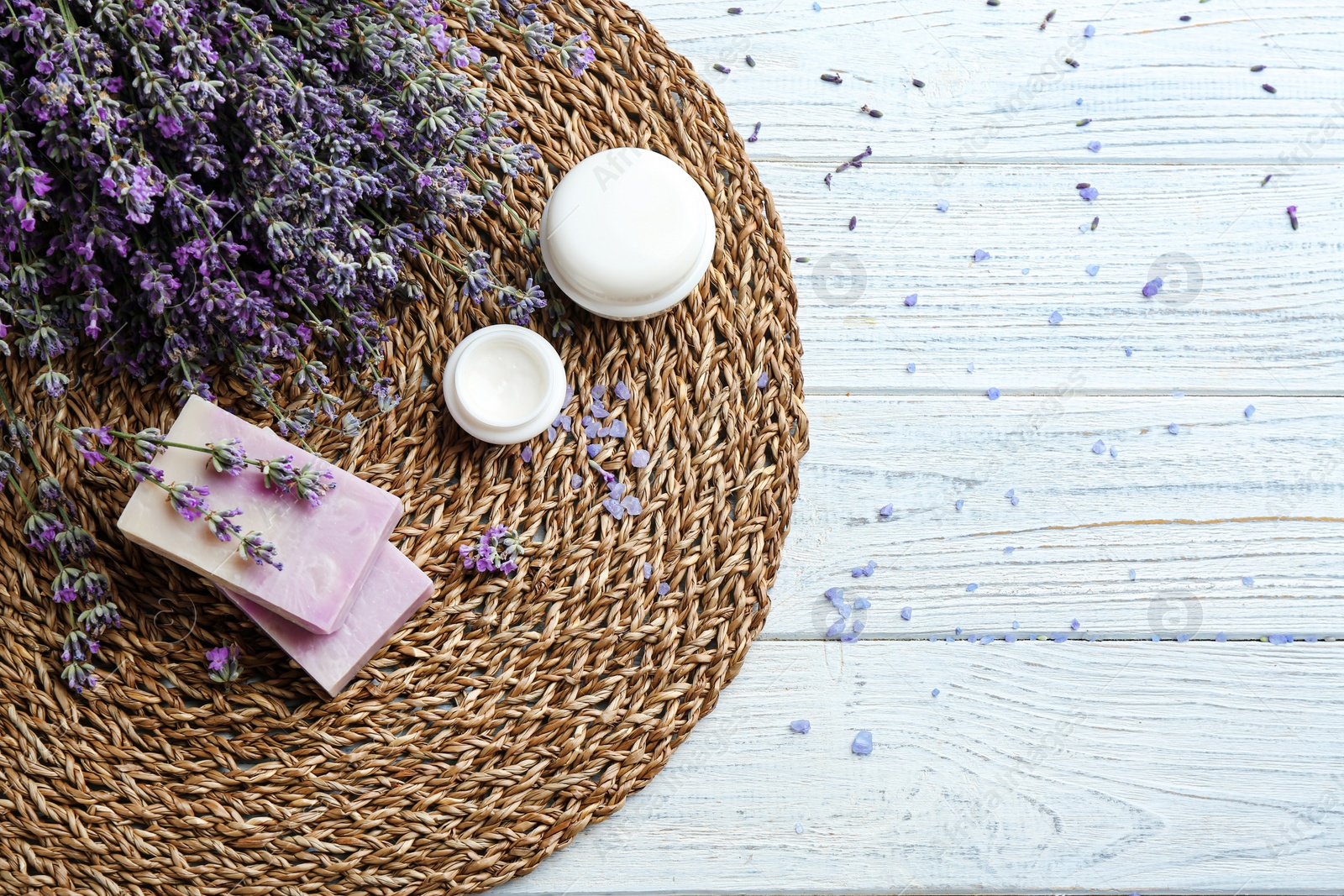 Photo of Flat lay composition of handmade soap bars with lavender flowers on white wooden background. Space for text