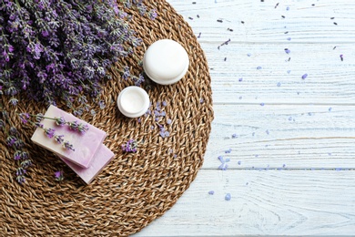 Flat lay composition of handmade soap bars with lavender flowers on white wooden background. Space for text