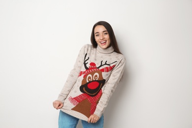 Photo of Young woman in Christmas sweater on white background