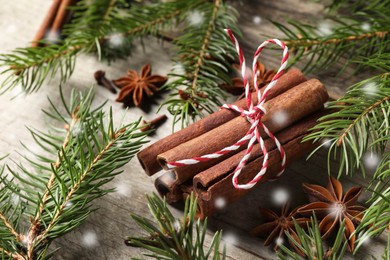 Image of Different spices and fir tree branches on wooden table. Cinnamon, anise, cloves