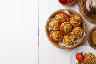 Fresh delicious puff pastry served with tea and tomatoes on white wooden table, flat lay. Space for text